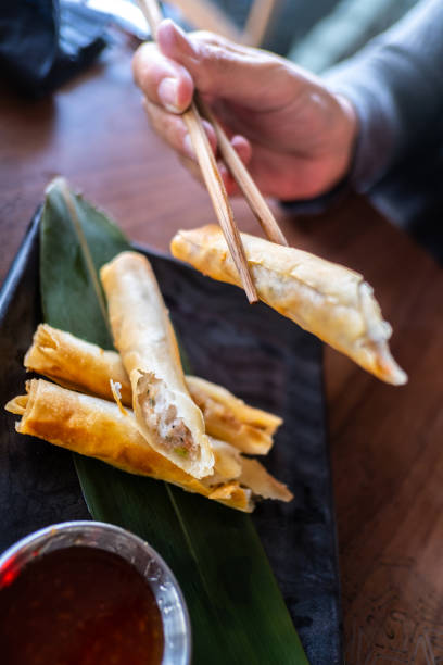 istock A woman eats Asian food with chopsticks 1355795205