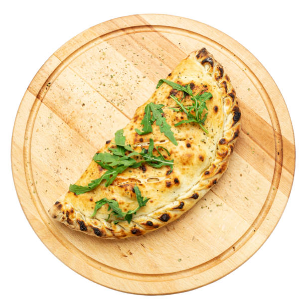 Traditional closed italian pizza calzone on wooden plate  isolated on white background. File contains clipping path.
