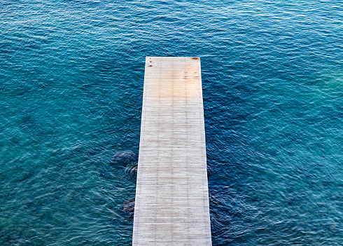 Wooden and metal jetty over calm water