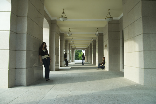 Young woman standing at city theater background