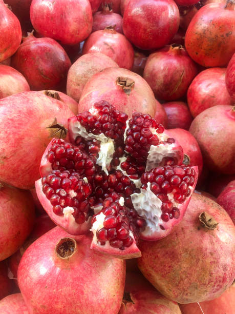istock background with whole and one cut pomegranate fruit with ripe red seeds 1355801851