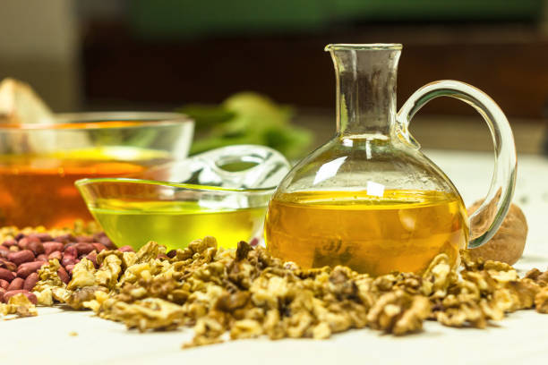 Walnut, peanut and soy oil on the kitchen table. Organic cold pressed oils, handcrafted bread and spices. Healthy food and ingredients composition