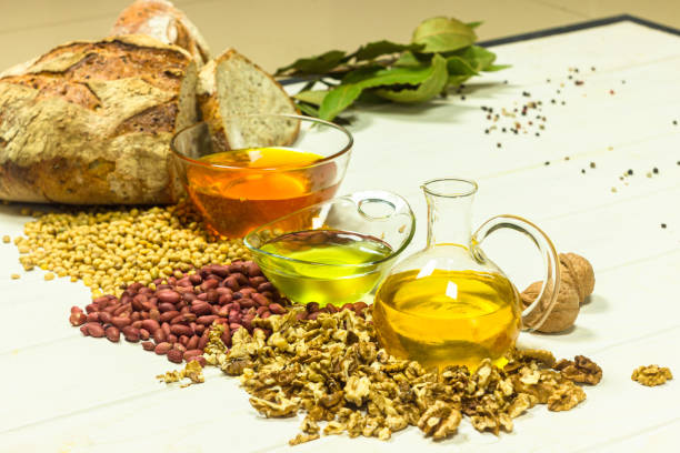 istock Walnut, peanut and soy oil on the kitchen table. Organic cold pressed oils, handcrafted bread and spices. Healthy food and ingredients 1355801916