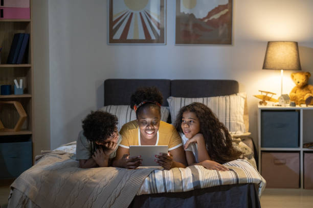 istock Happy Mother Reading To Kids Before Bedtime 1355807220