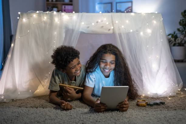 istock Cheerful Brother And Sister With Tablet 1355807297