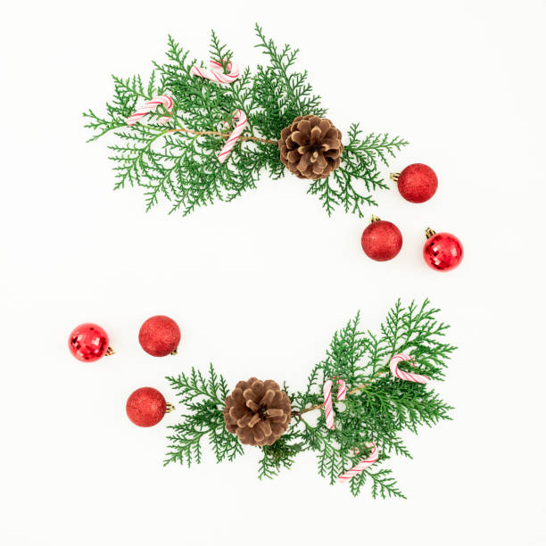 istock Merry Christmas frame composition with green branches and red balls on white background. Flat lay, top view 1355810652