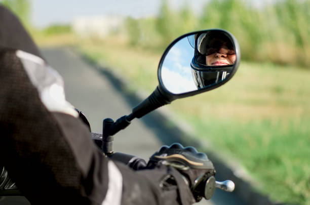 istock An elderly woman rides a motorcycle. Reflection in the mirror while riding a motorcycle. 1355810669
