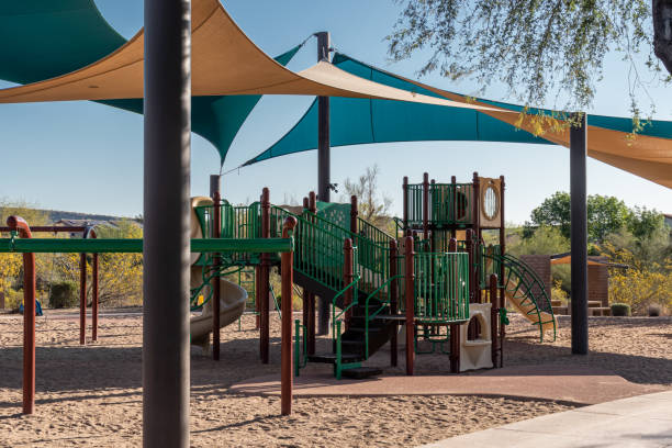 spielplatzstruktur mit schattenspendenden stoffbelägen und sand - kinderspielplatz stock-fotos und bilder