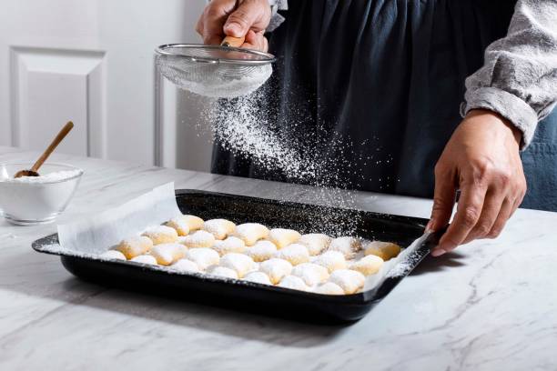 istock Coating vanillekipferl Cookie with Sugar Dust Using Strainer, Fresh Home Baked Christmas Cookies on the Table. Popular as  Putri Salju in Indonesia 1355814719