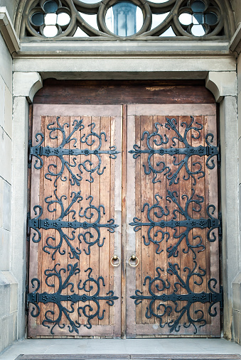 Ancient wooden doors of Church of Sts. Olha and Elizabeth in Lviv, Ukraine. Old medieval woods decorated doorway of Cathedral, soft selective focus