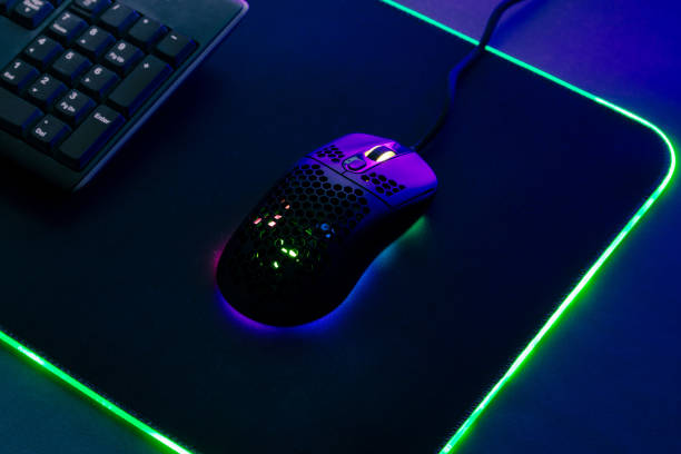 istock Light weight gaming mouse on gaming mat with led light, close-up 1355815994