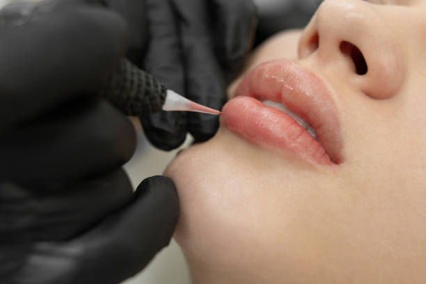 close-up of the permanent makeup procedure. lip makeup in the cosmetologist's salon. - portrait tattoo photography color image imagens e fotografias de stock