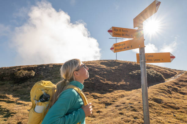 istock Woman hiking on mountain ridge, clouds 1355818991