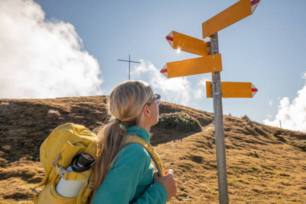 istock Woman hiking on mountain ridge, clouds 1355819054