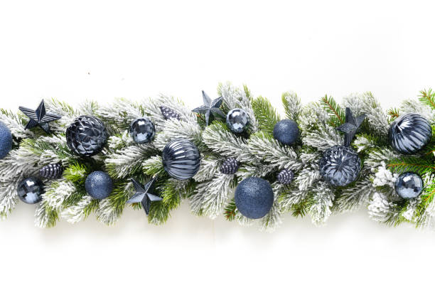 istock Christmas banner with blue baubles in row on snowy evergreen branches. 1355819186