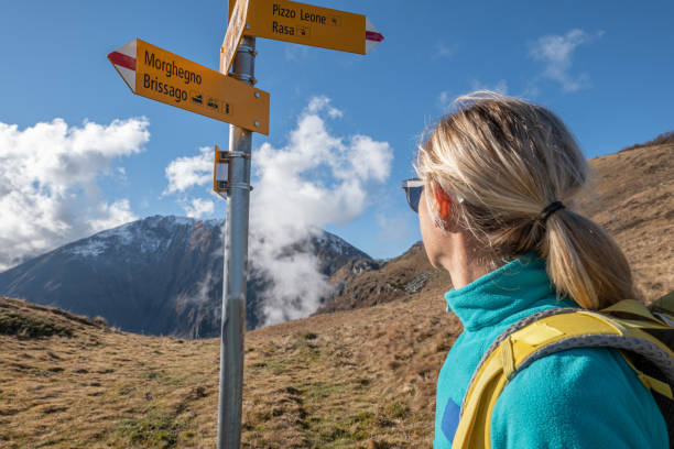 istock Woman hiking on mountain ridge, clouds 1355819355