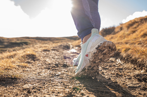 Close up on woman's shoes wile she hikes on mountain terrain