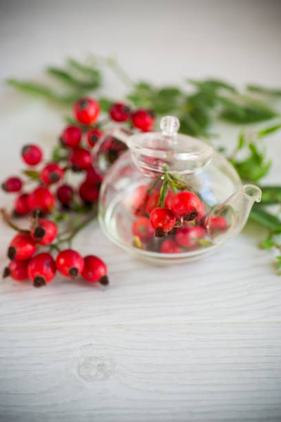 a bunch of ripe red rose hips on a wooden table