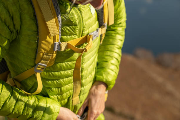 istock Young woman on a hike adjusts jacket, unrecognisable people 1355823635