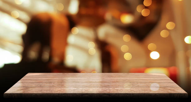 istock Empty wooden table top with lights bokeh on blur restaurant background 1355825034