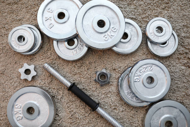 istock Pile of shiny chrome dumbbells disks lying around grip 1355825348
