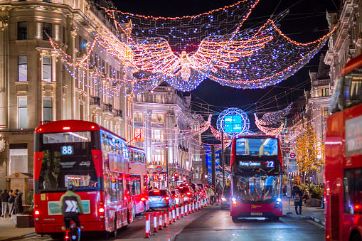 London UK - November 18, 2021:  Festive decorations and Christmas lights at Regent street, cars, buses and people walking on the street