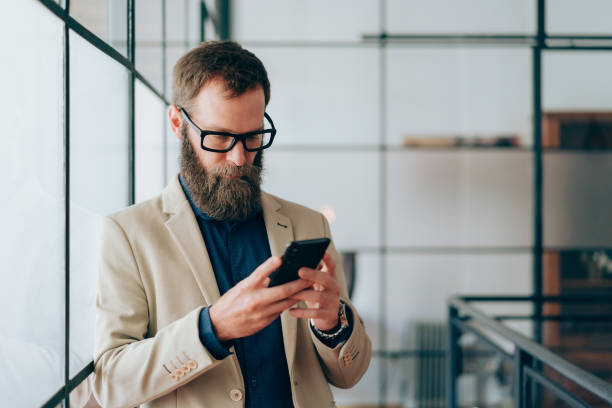 istock Businessman in the office texting on smartphone 1355828476