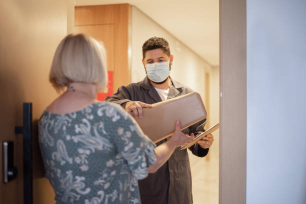 istock Woman getting her purchase at home wearing face mask. 1355830850
