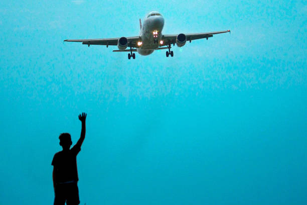 istock an airplane and a child waving 1355832506