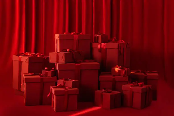 Photo of Large gift boxes with a bow on a red background