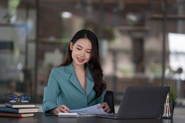 istock Businesswoman using calculator and reading financial documents. 1355832851