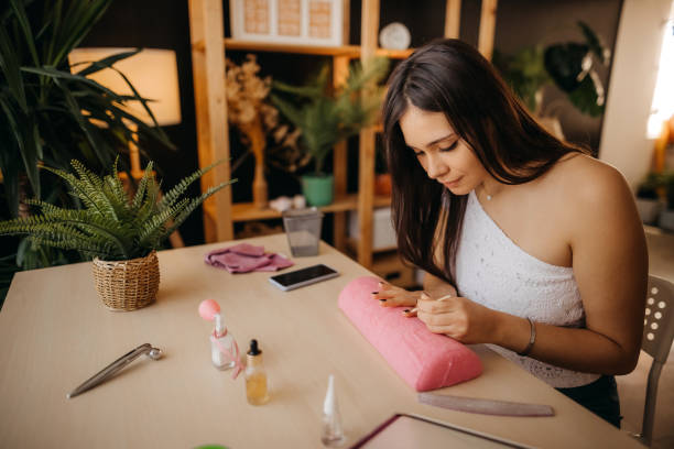 istock Woman applying manicure 1355836589