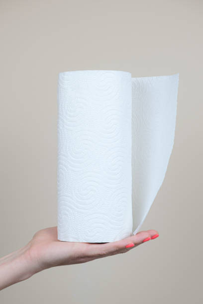 istock A woman's hand holds a roll of paper kitchen towels. Vertical image 1355837789
