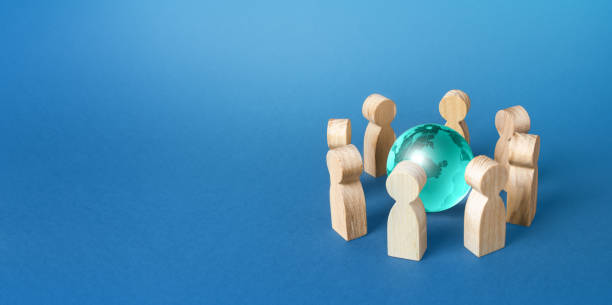istock People surround a blue earth globe. Cooperation and collaboration. Joining forces to solve global problems. Negotiations. Teamwork. Remote work and outsourcing. Communication technology. Education 1355839102