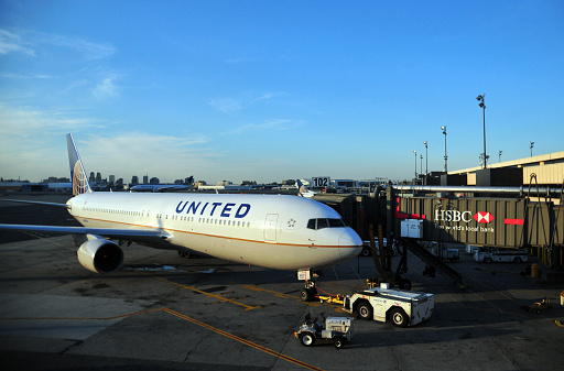 Manhattan, New York, USA: United Airlines N670UA (Boeing 767 - MSN 29240) - with tugs at a passenger boarding bridge in Newark Liberty International Airport Terminal C, is exclusively operated by and for United Airlines and its regional carrier United Express for their global hub at EWR.