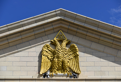 Denver, CO, USA: Scottish Rite Masonic Center, Colorado Consistory No. 1 - neoclassical building, completed in 1925, architect William Norman Bowman - double-headed eagle at the crest of the western pediment. The metal eagle carry a pyramid with the number 32 on their heads - Capitol Hill neighborhood.