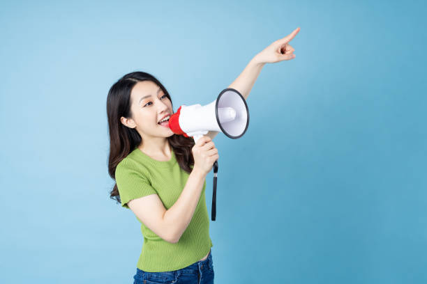 asian girl portrait holding speaker, isolated on blue background - filipino ethnicity audio imagens e fotografias de stock