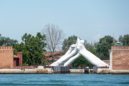Venice, Italy - July 1, 2021: Venice, Italy Venice Biennale, Lorenzo Quinn - Building Bridges hands sculpture.
