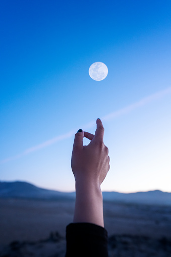 hand view, hand pointing or touching the sky and Moon