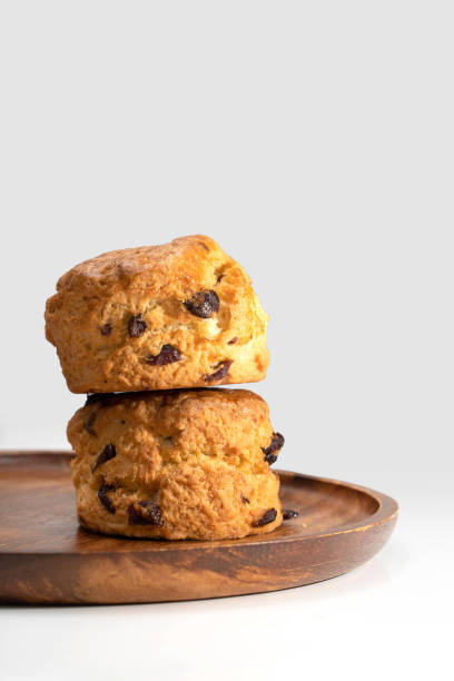 istock traditional british Scones on wooden plate on white background 1355842753