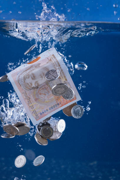 concepto de blanqueo de capitales - british coin coin falling british currency fotografías e imágenes de stock