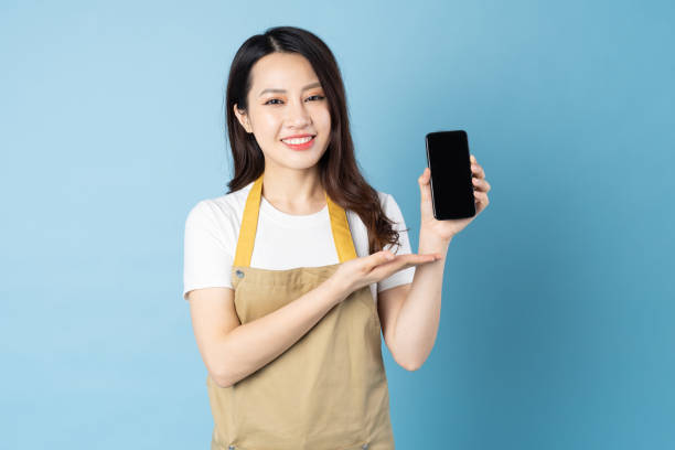 istock Asian girl portrait sitting on white cube, isolated on blue background 1355843836