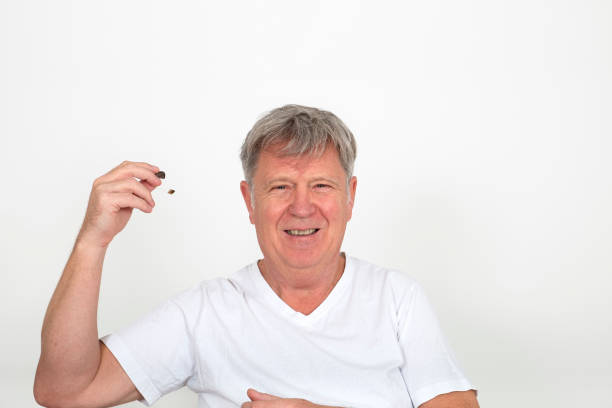 mature man using hearing aids to compensate hearing loss