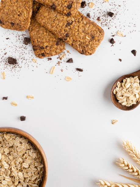 marco para texto hecho de galletas de avena (barras de muesli), chispas de chocolate, espiguillas de trigo y copos de avena (avena enrollada) en tazón de madera. - chocolate chip cookie bakery chocolate homemade fotografías e imágenes de stock