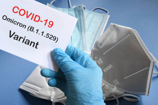 istock Doctor's hand in blue glove with white paper and text Covid-19 Omicron Variant with various protection masks on background. COVID-19 omicron variant strain protection concept. 1355846343