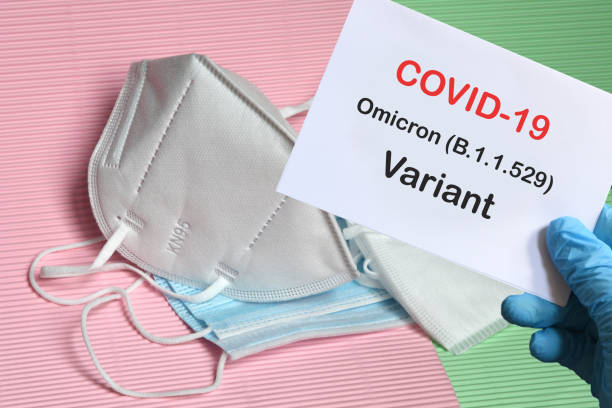 istock Doctor's hand in blue glove with white paper and text Covid-19 Omicron Variant with various protection masks on background. COVID-19 omicron variant strain protection concept. 1355846367