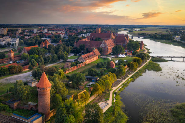 Beautiful Malbork castle over the Nogat river at sunset Malbork, Poland - September 18, 2019: Beautiful Malbork castle over the Nogat river at sunset, Poland malbork photos stock pictures, royalty-free photos & images