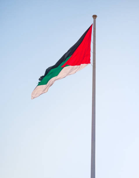 istock Jordanian flag waving in the wind against blue sky. 1355849034