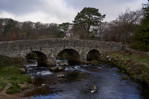 Historic stone bridge over the East Dart River on Dartmoor in Devon, United Kingdom