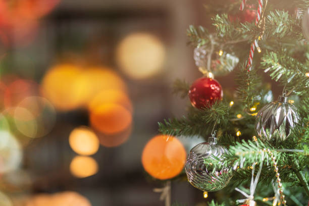 fondo de navidad - bolas y rama de abeto, bola roja de navidad brillante que cuelga de las ramas de pino con fondo festivo, primer plano de la bola roja que cuelga de un árbol de navidad decorado - christmas tree decorations indoors selective focus arrangement fotografías e imágenes de stock